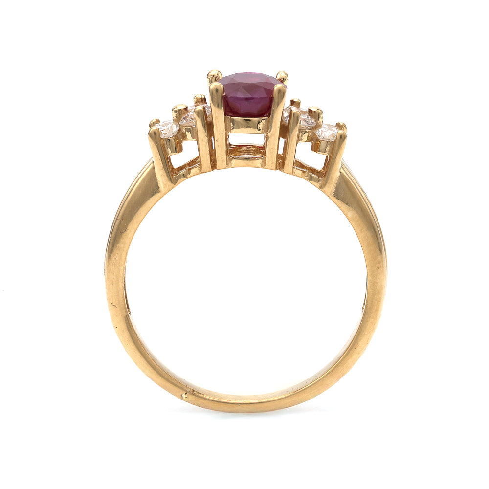 18K gold ring with oval ruby centerpiece.