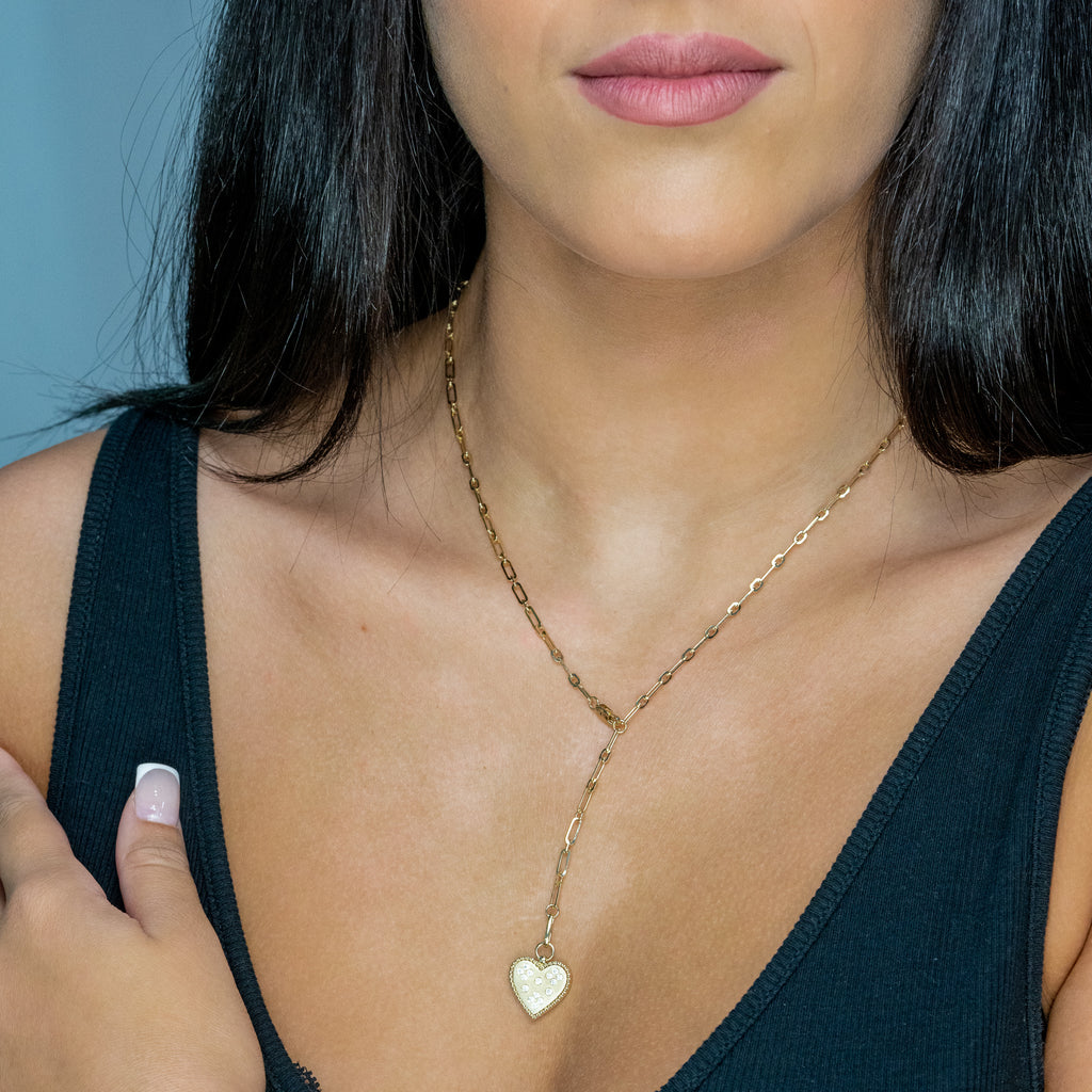 Heart-shaped diamond necklace on gold chain.