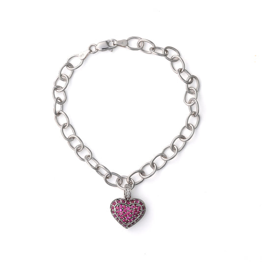 Heart-shaped ruby charm bracelet in white gold.