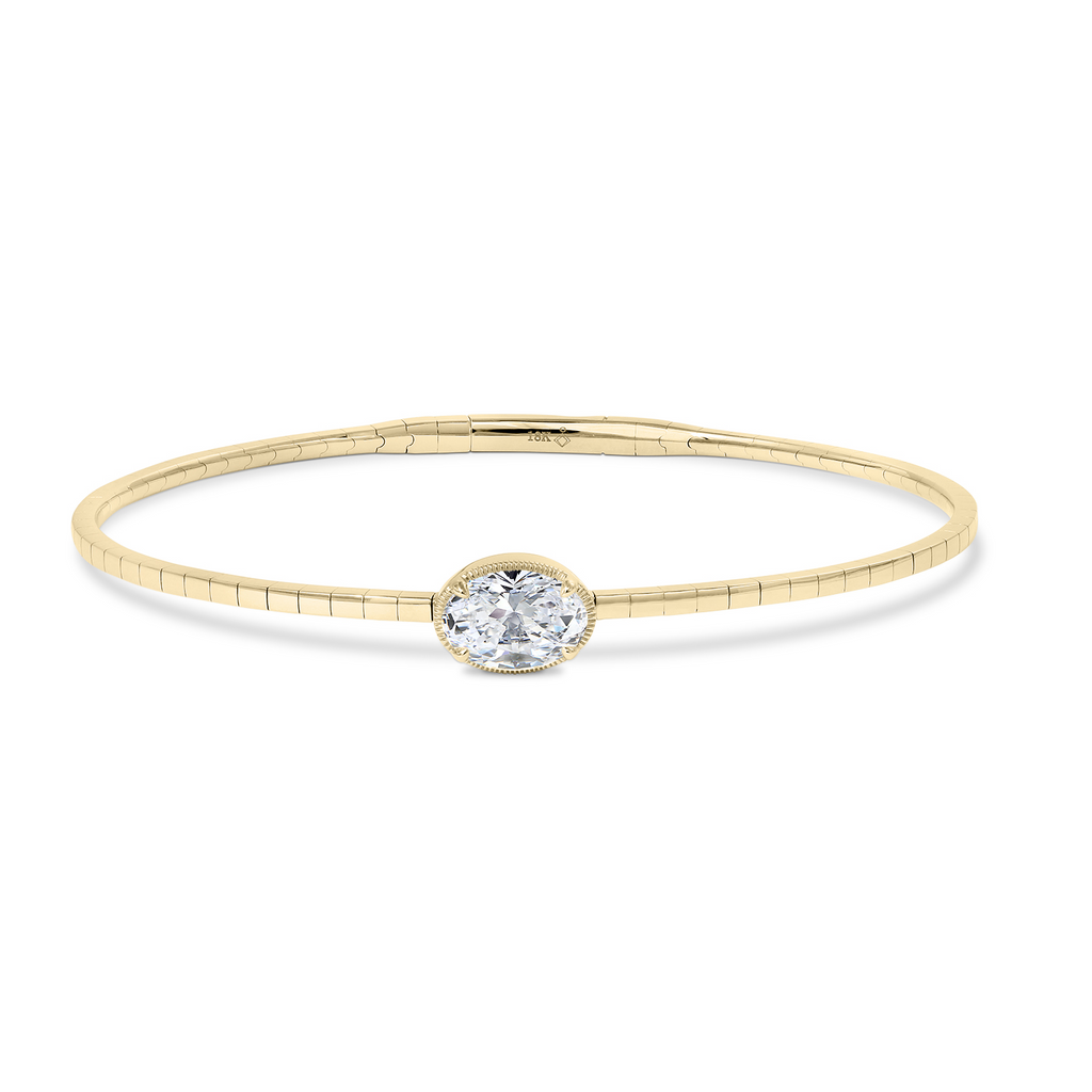 Oval diamond yellow gold bangle bracelet.