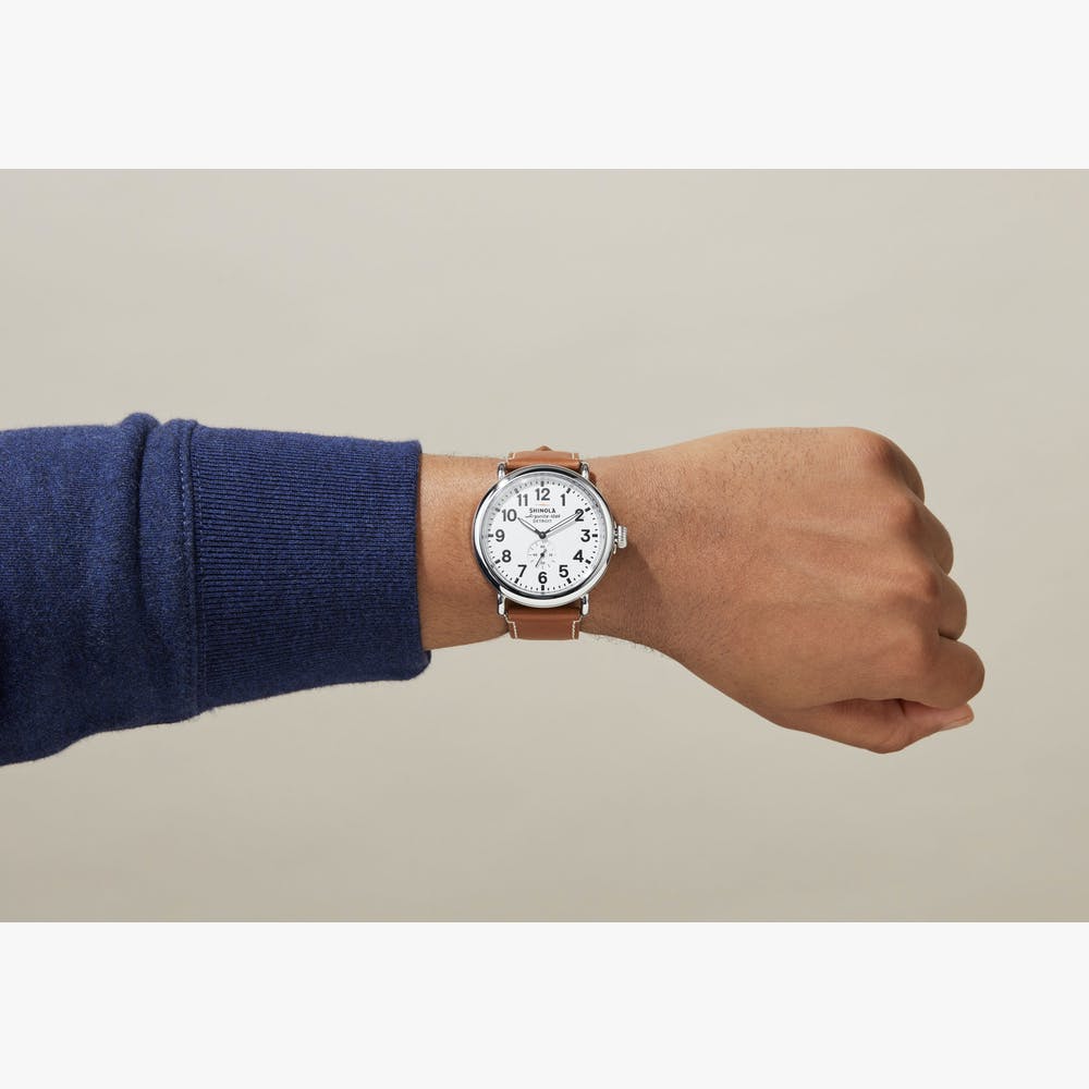 Silver watch with white dial, leather band.