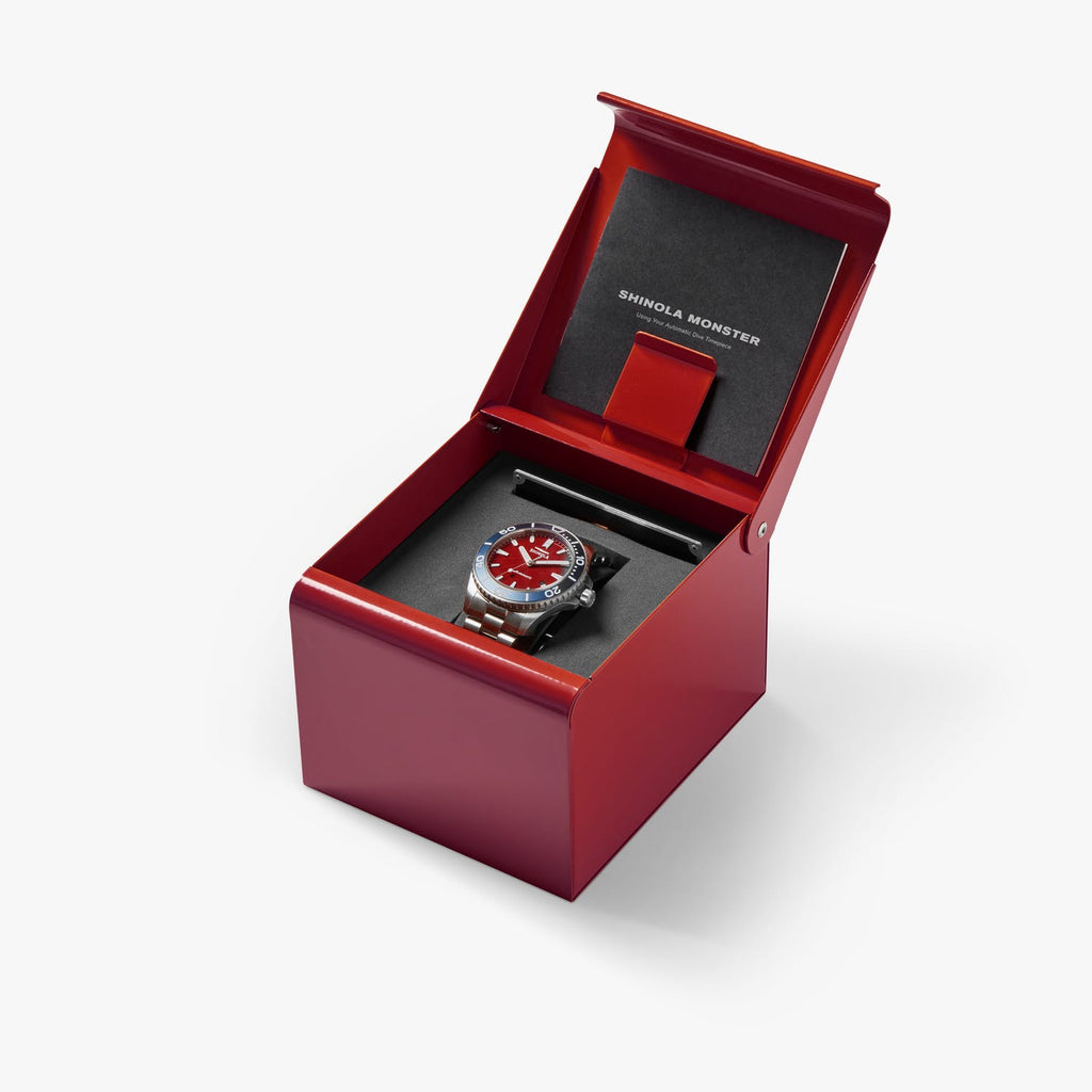 Red dial stainless steel watch in red box.