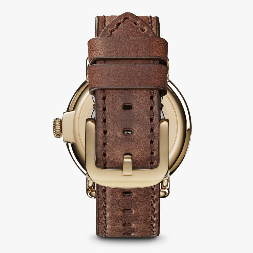 Brown leather watch strap with gold buckle.