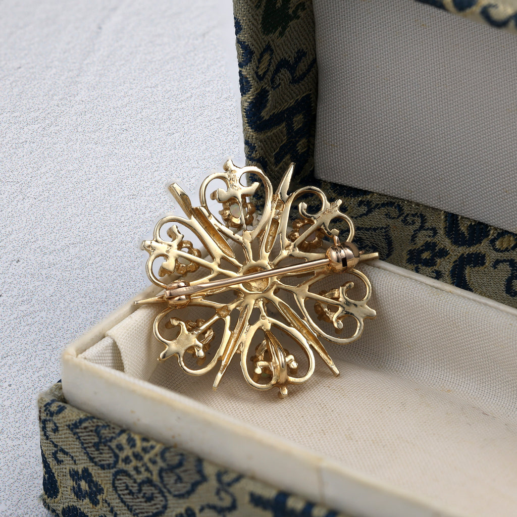 Starburst opal pin in yellow gold.