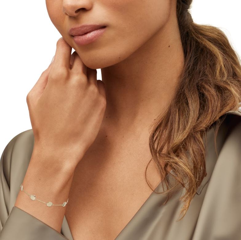 14K yellow gold station bracelet on wrist.