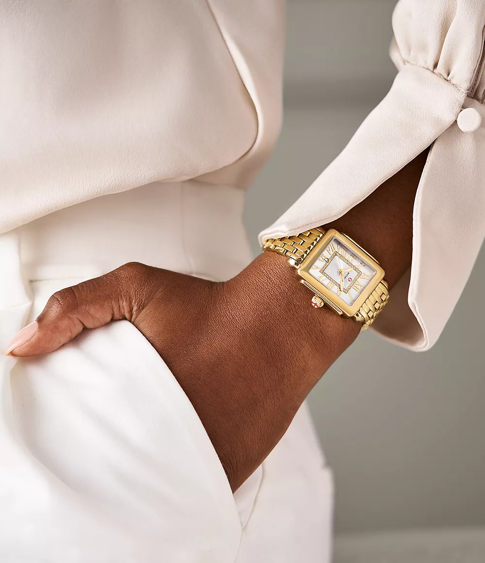 Gold-plated watch with diamond accents on wrist.
