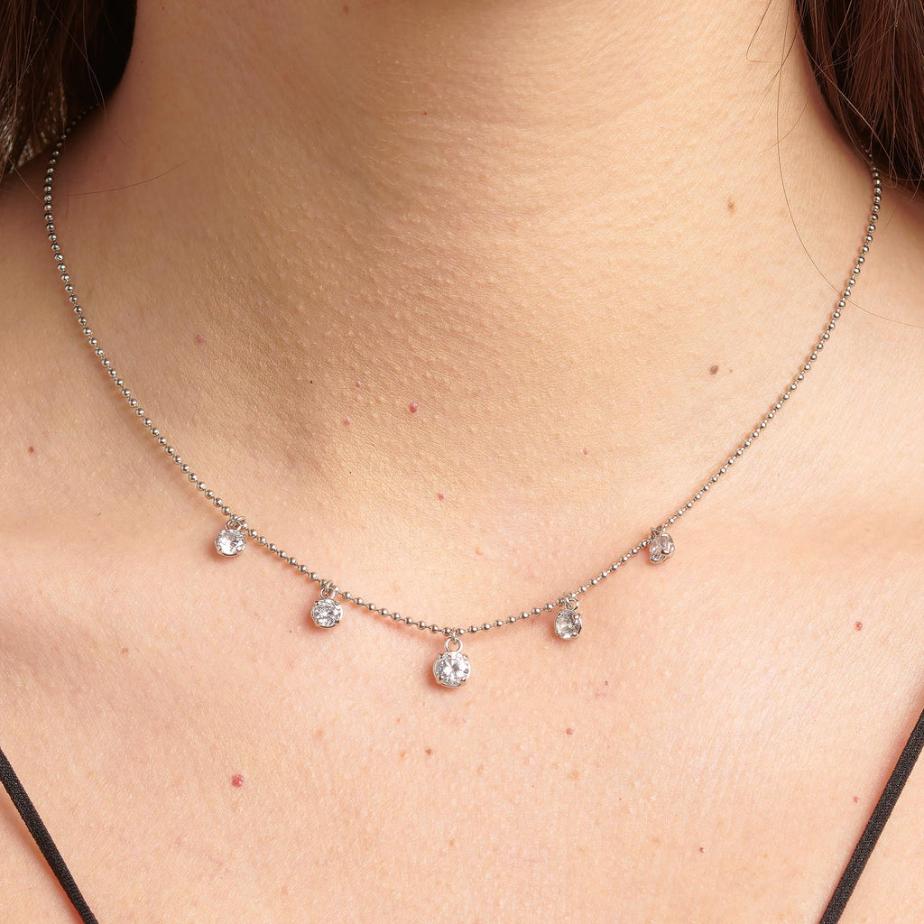 Stainless steel necklace with dangling simulated diamonds.