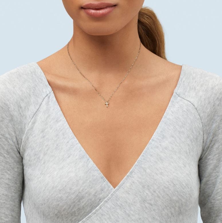 14K yellow gold cross necklace on model.