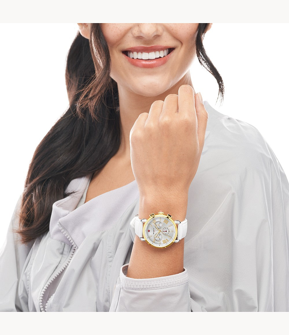 Silver dial, gold bezel, white silicone band.