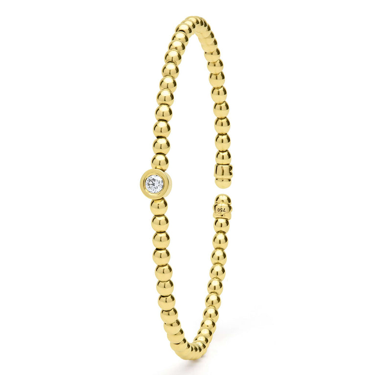 Gold beaded cuff with diamond accent.