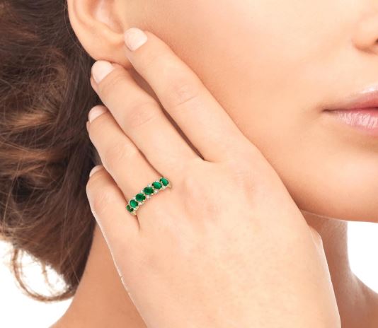 Emerald and diamond band on hand.