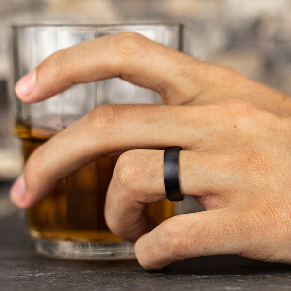 Black titanium carved band on finger.