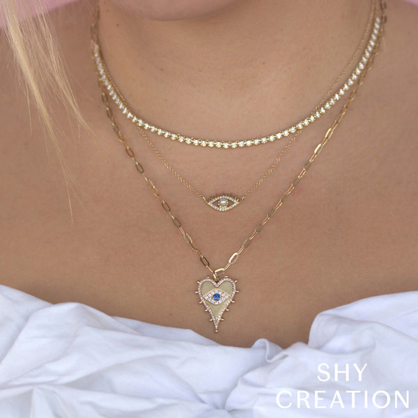 Heart-shaped diamond necklace with sapphire accent.