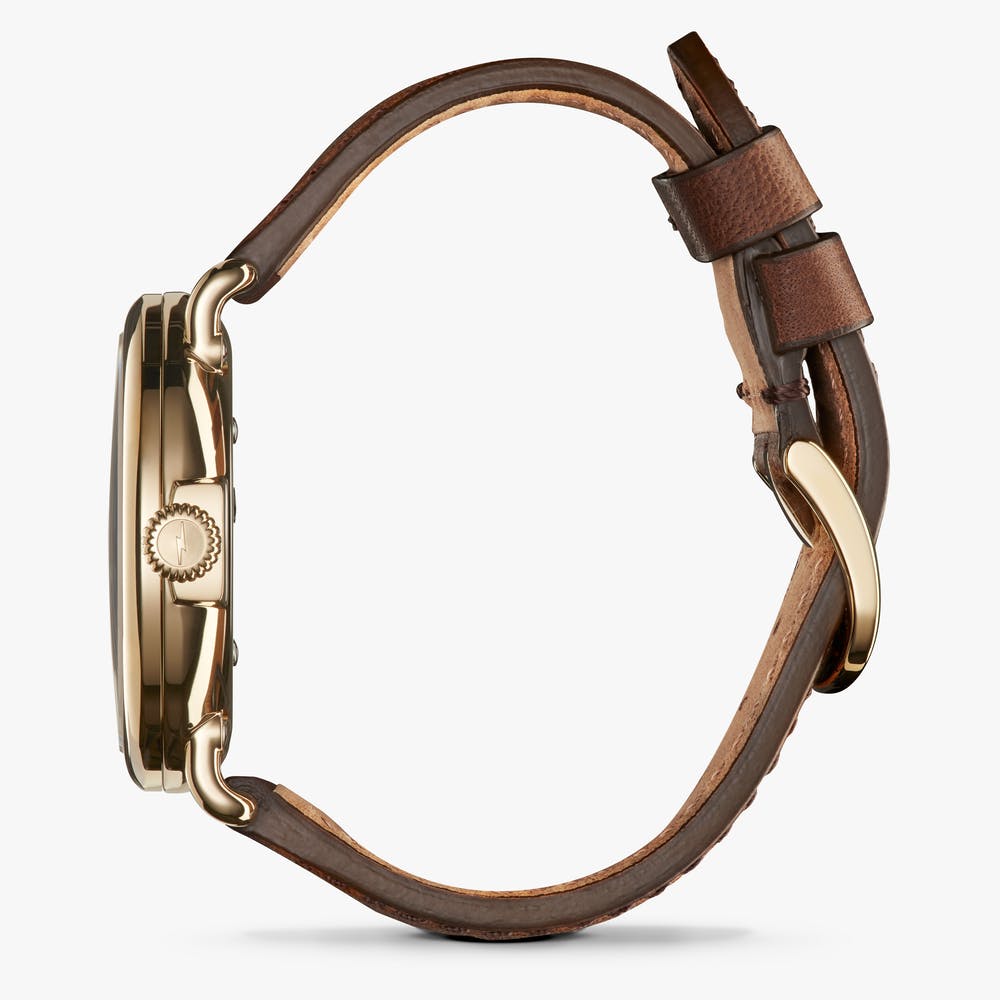 Brown leather band, gold-tone case, side view.