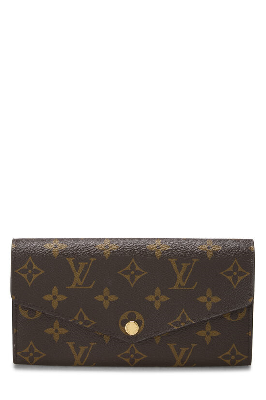 Brown leather wallet with gold monogram pattern.