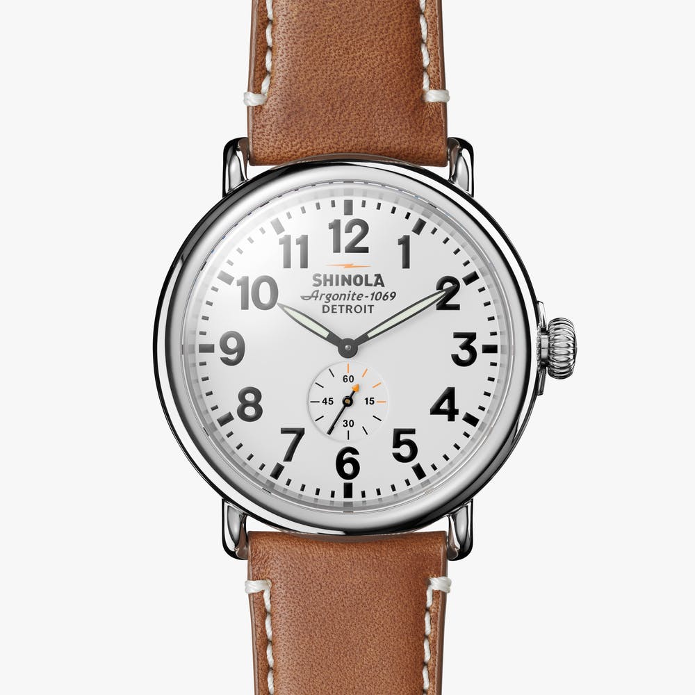 Silver round watch with brown leather band.