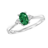 Oval emerald ring with diamond accents.