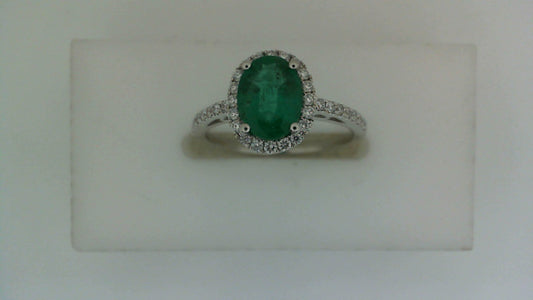 Oval emerald with diamond halo in white gold.