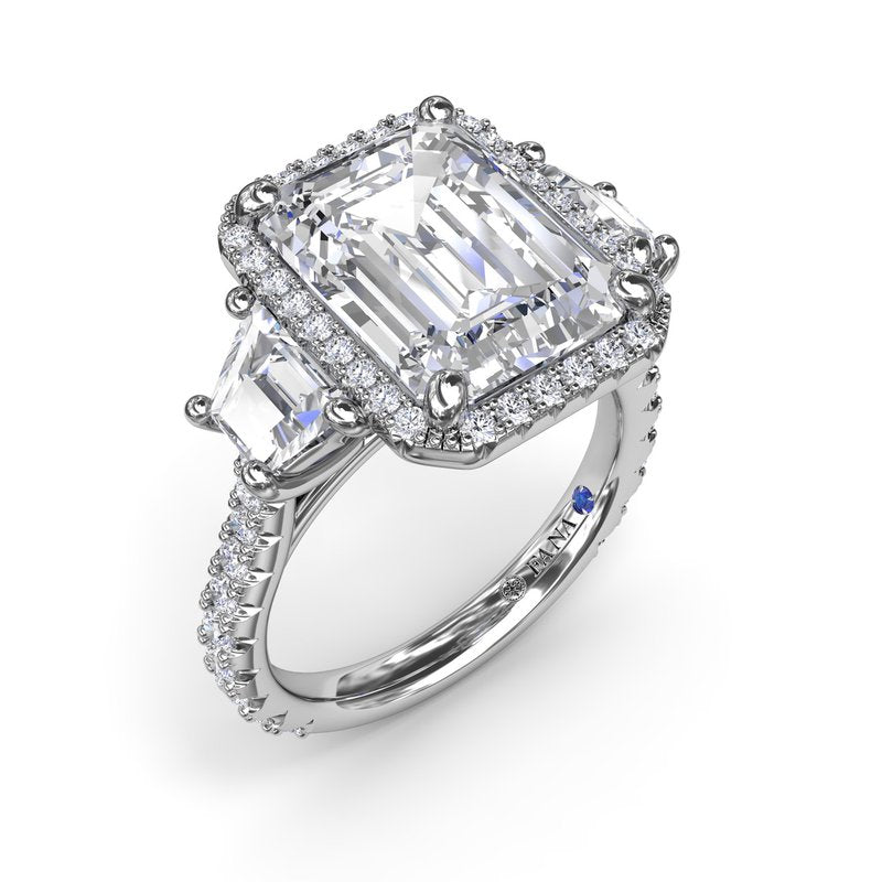 Halo three-stone diamond ring in white gold.