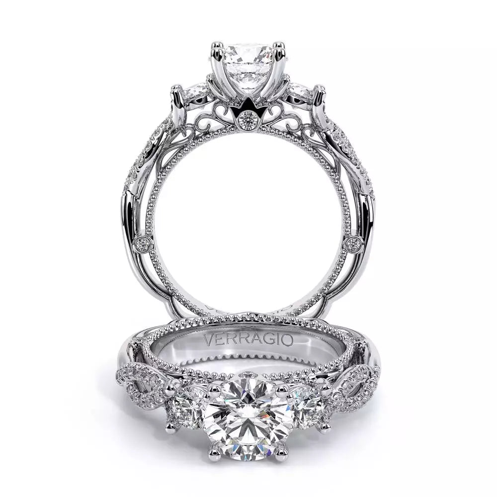 Three-stone diamond ring, intricate white gold design.