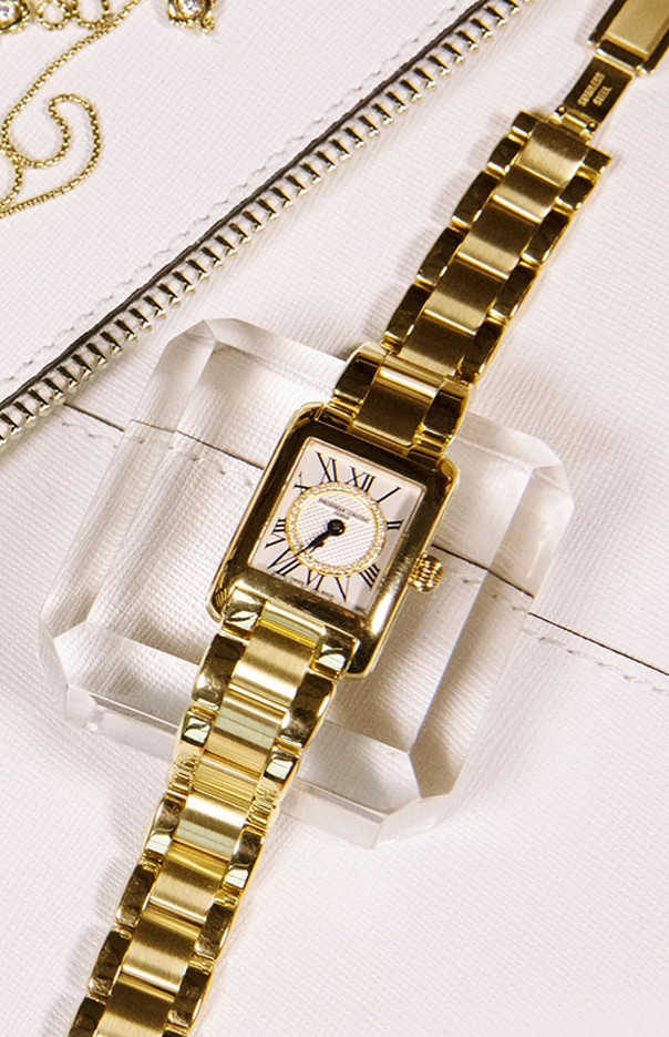 Gold watch with Roman numerals and bracelet.