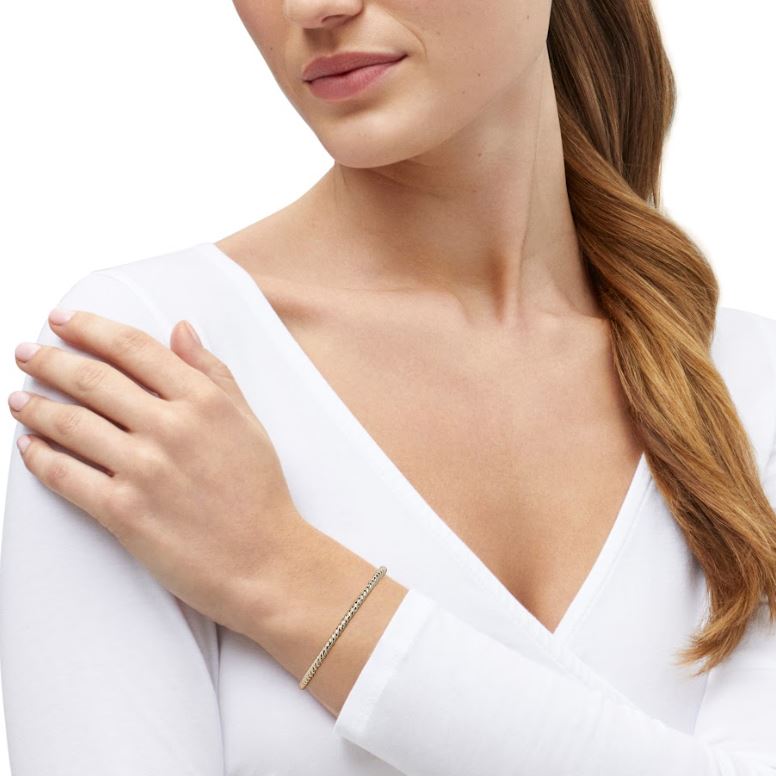 14K yellow gold minimalist bracelet on wrist.