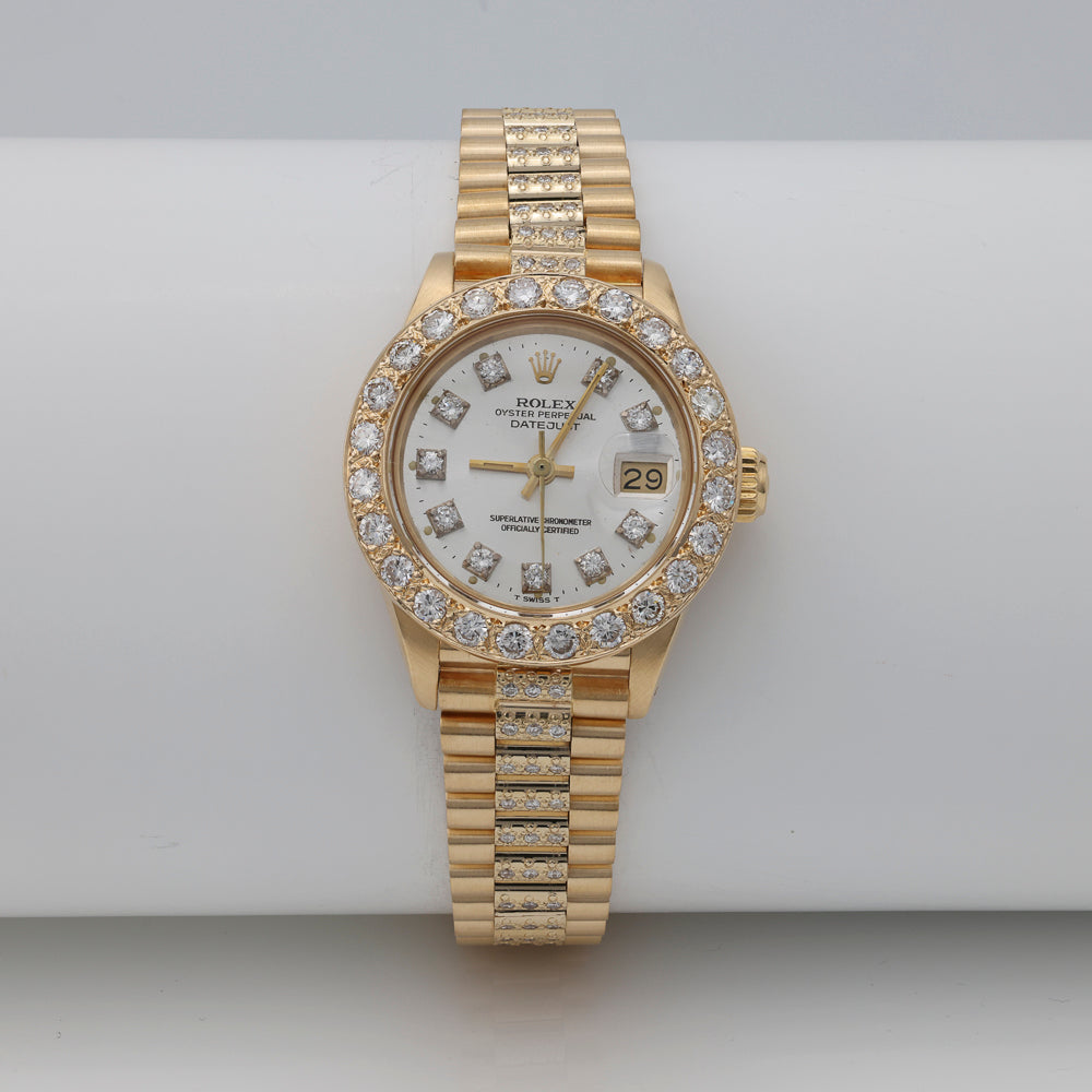 Gold Rolex watch with diamond bezel.