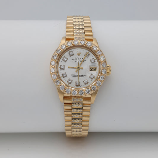 Gold Rolex watch with diamond bezel.