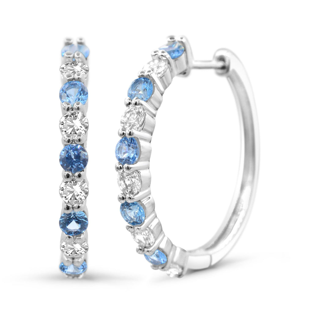Sterling silver hoops with blue topaz gemstones.