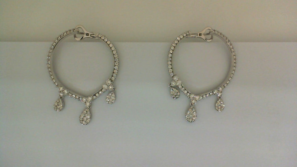 Round diamond earrings with dangling teardrop accents.