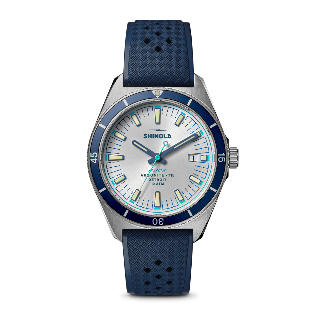 Silver dial, blue bezel, rubber strap watch.