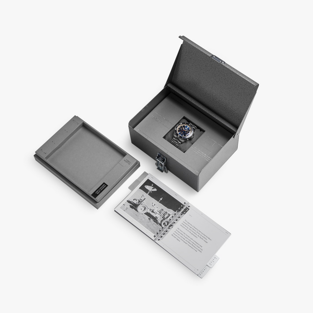 Blue-dial titanium watch in presentation box.