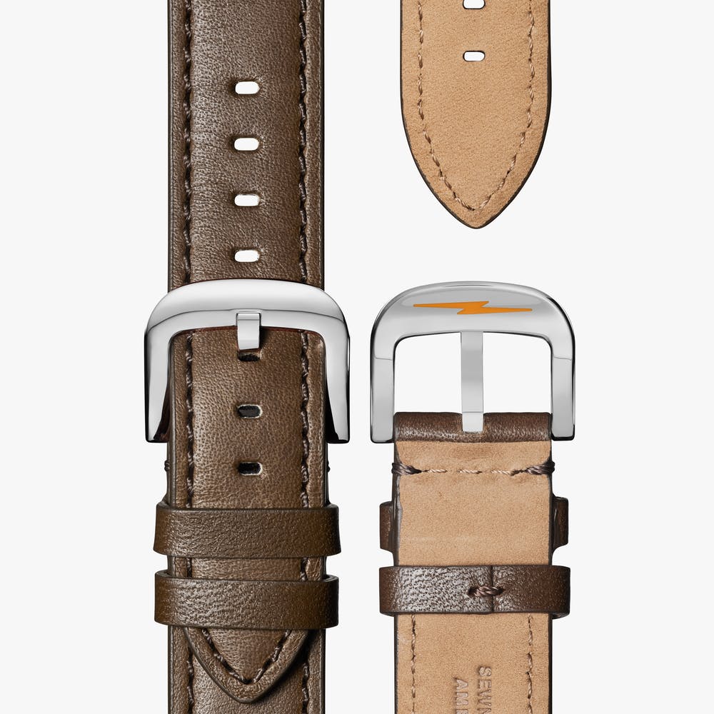 Brown leather watch strap with silver buckle.