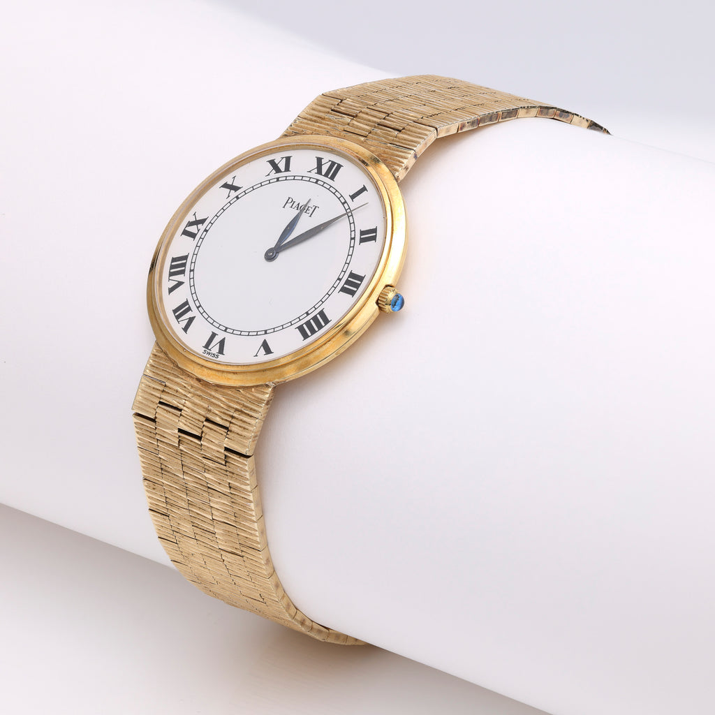 Gold watch with Roman numeral dial.