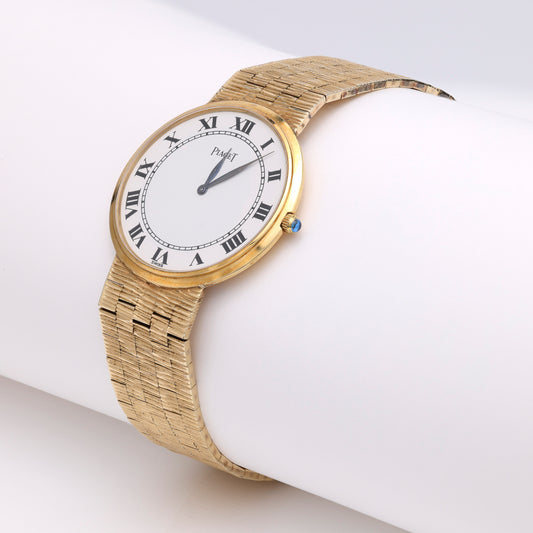 Gold watch with Roman numeral dial.