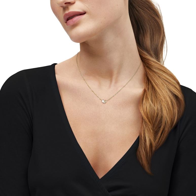 14K yellow gold heart necklace on model.