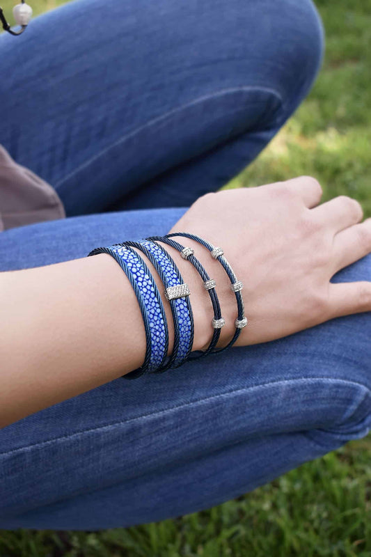 Blue diamond bracelet on wrist outdoors.
