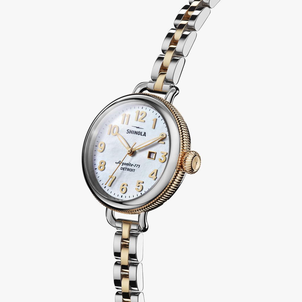 Gold-accented watch with mother-of-pearl dial.