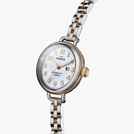 Gold-accented watch with mother-of-pearl dial.
