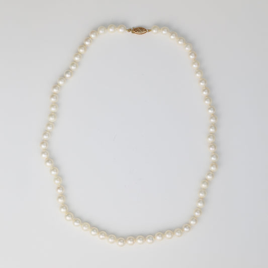 Pearl necklace with gold clasp.