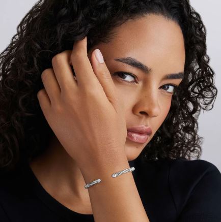 Sterling silver bangle with round diamond accents.
