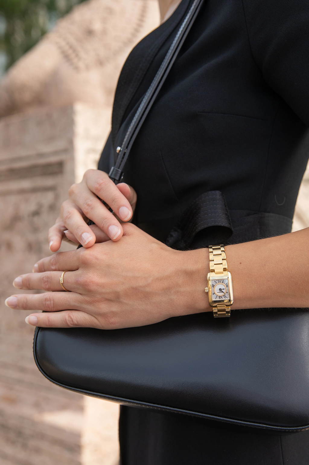 Gold watch with silver rectangular dial.