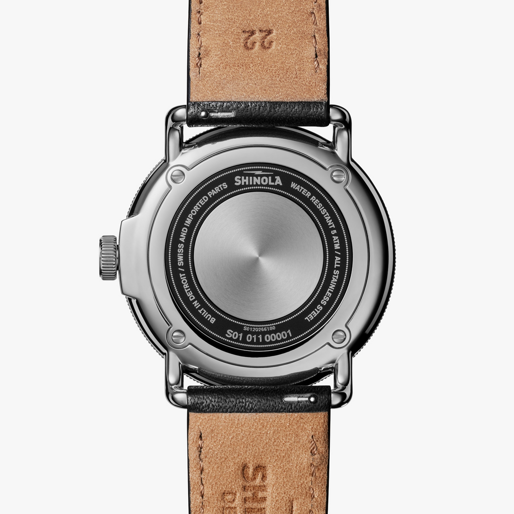 Stainless steel watch back with leather strap.