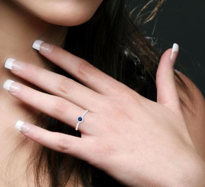 Sapphire and diamond ring on hand.