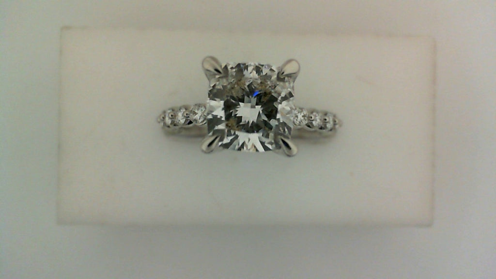 Cushion diamond engagement ring with side stones.