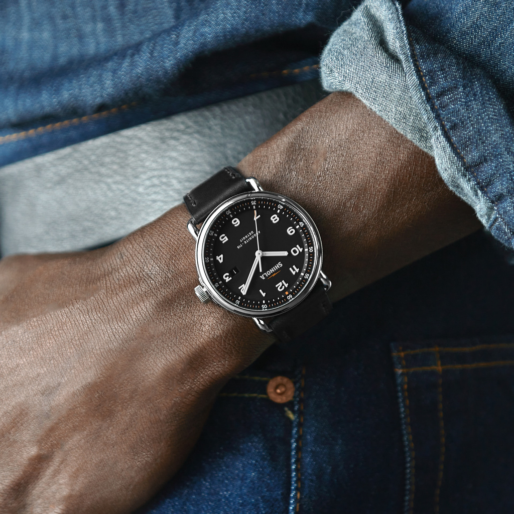Black dial watch, stainless steel case, leather strap.