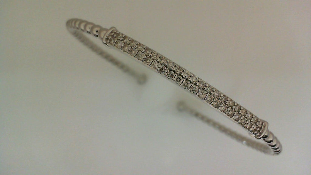Flexible white gold bangle with round diamonds.