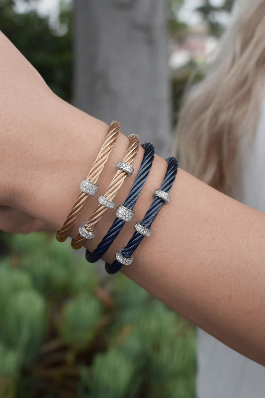 Stainless steel cable bracelets with diamond accents.