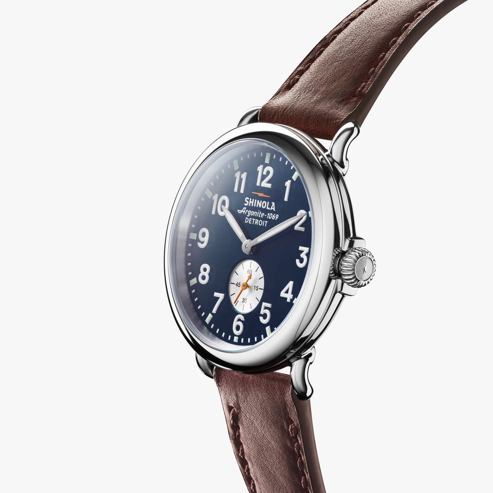 Men's watch with blue dial, brown leather strap.