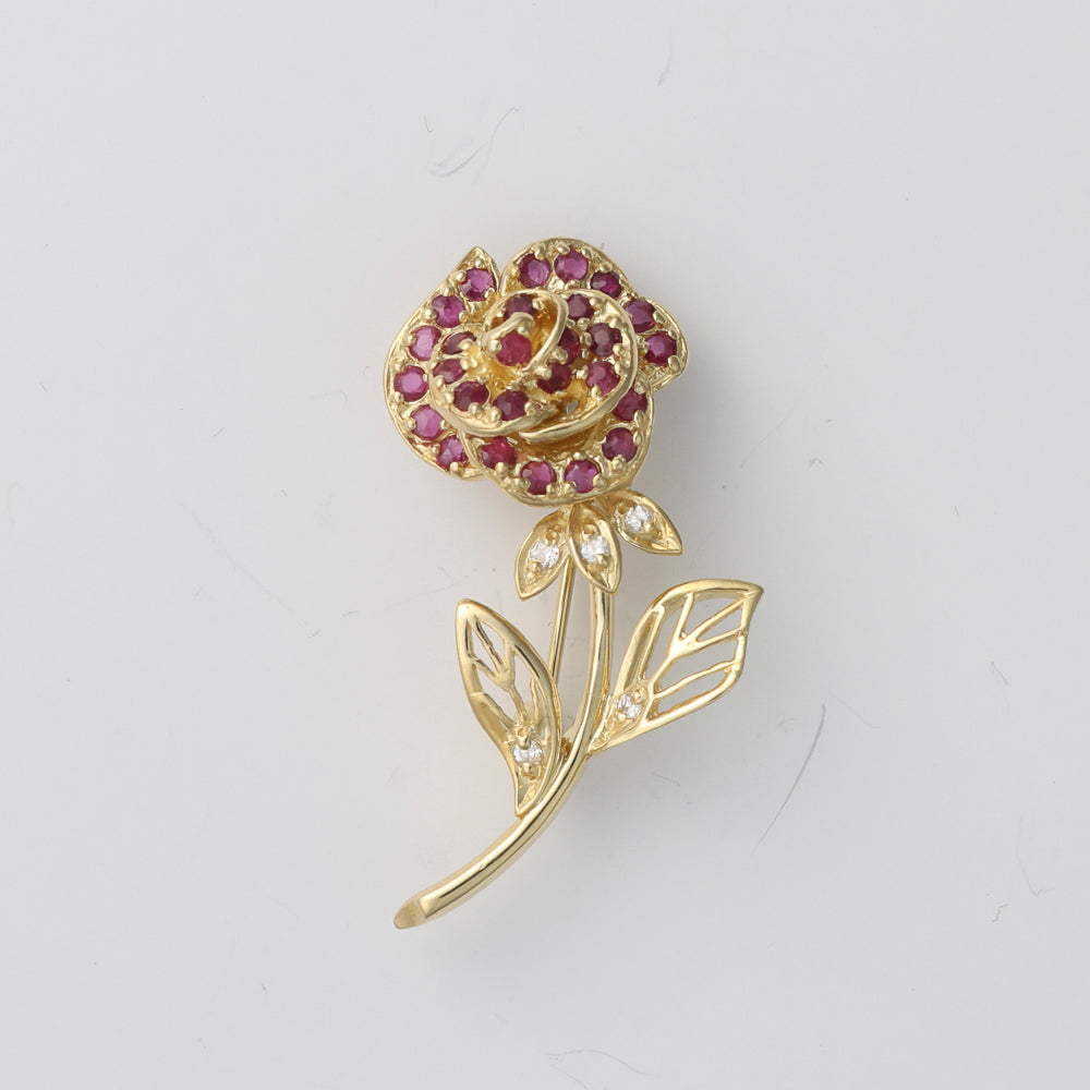 Ruby and diamond rose pin in gold.